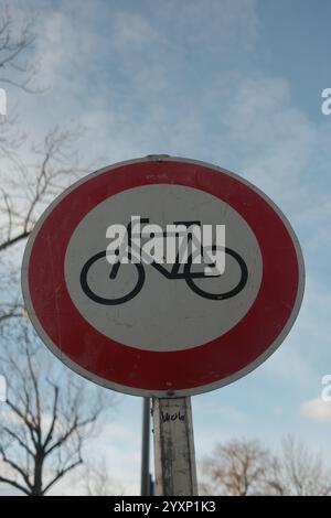 Ein rot-weißes Schild mit einem Fahrradsymbol darauf. Das Schild steht auf einem Pfosten und ist von Bäumen umgeben Stockfoto