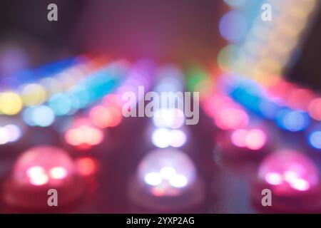 Ein unscharfes Bild einer Tastatur mit vielen bunten Lichtern. Die Lichter sind so angeordnet, dass sie den Augen einer Person ähneln. Das Konzept der Erreger Stockfoto