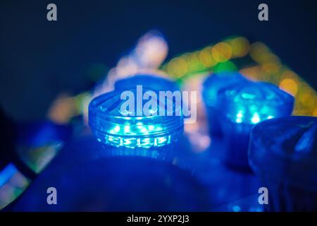 Drei blaue Lichter, die aufleuchten und auf einen Tisch gestellt werden. Die Lichter sind so angeordnet, dass sie alle in die gleiche Richtung zeigen, wodurch ein SENSE entsteht Stockfoto