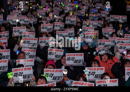 Seoul, Südkorea. Dezember 2024. Die Demonstranten schwenken K-POP-Lichtstäbe mit Plakaten mit der Aufschrift „sofortige Verhaftung“ während einer Kundgebung, die die Verhaftung des angeklagten südkoreanischen Präsidenten Yoon Suk Yeol in der Innenstadt von Seoul fordert. Quelle: SOPA Images Limited/Alamy Live News Stockfoto