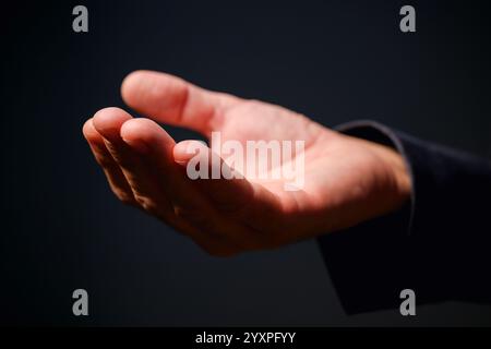 Männliche Hand mit Handfläche nach oben, Geschäftsmann im Anzug mit leerer Hand als Modellkopierraum, selektiver Fokus Stockfoto