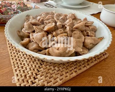 Manti traditionelle türkische Speisen Ravioli mit Joghurt und Tomatensauce auf Teller. Bereit zum Essen Stockfoto