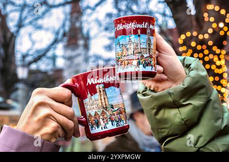Heißer Glühwein gegen die Kälte, Besucherinnen trinken Glühwein auf dem Viktualienmarkt, München, Dezember 2024 Deutschland, München, Dezember 2024, Glühwein trinken auf dem Viktualienmarkt, zwei Besucherinnen stoßen mit ihren Tassen an, genießen den heißen Glühwein gegen die Kälte, Glühwein für 5 Euro pro Tasse, Winter, Bayern, bayerisch, *** Glühwein gegen die Kälte, Besucher trinken Glühwein auf dem Viktualienmarkt, München, Dezember 2024 Deutschland, München, Dezember 2024, beim Glühwein auf dem Viktualienmarkt stoßen zwei Besucher mit ihren Tassen an und genießen wieder den heißen Glühwein Stockfoto
