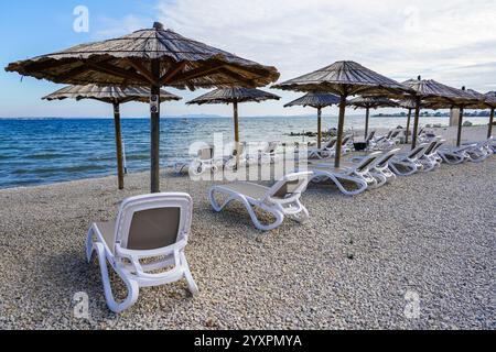 Leeres Strandcafé ohne Besucher nach Ende der Saison, Schilfsonnenschirme, leere Liegen, Adria, Kroatien Stockfoto