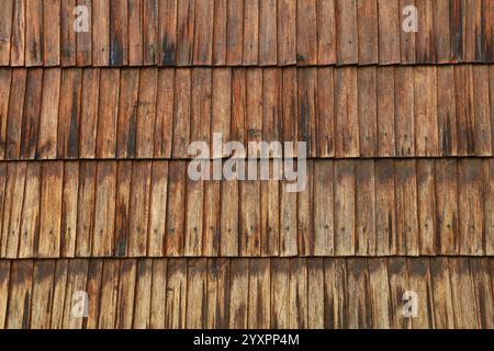 Nahaufnahme von überlappenden alten Holzschindeln, die eine strukturierte Oberfläche auf der Außenseite eines Gebäudes bilden und Verwitterung und Naturholz grai zeigen Stockfoto