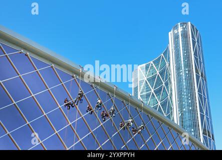 Eine Besatzung von Arbeitern reinigt die Fassade eines modernen Gebäudes des TELUS Convention Centre in Downtown Calgary, Kanada. Seit 1974 Stockfoto