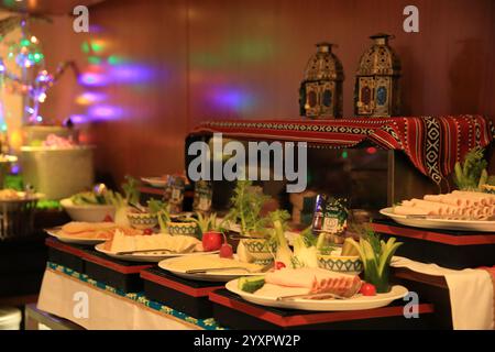 Buffet mit einer Auswahl an wunderschön eingerichteten Gerichten, ergänzt durch eine lebendige Einrichtung und funkelnde Lichter, schaffen eine festliche Atmosphäre Stockfoto