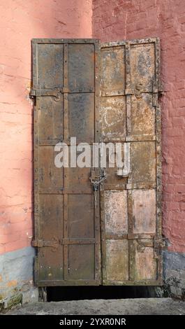 Eine alte Stahltür mit Griffen und Bolzen. Stockfoto