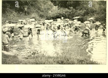 African Game Trails, 1910, Jagd, Uganda, Beschreibung und Reise, Afrika Ost, in dieser Szene waten eine Gruppe von Menschen durch einen Fluss, die fleißig schwere Lasten auf dem Rücken tragen. Das Wasser spiegelt die üppige Vegetation wider und die ferne Umrisse einer Siedlung sind entlang des Flusses zu sehen. Die einzelnen Menschen werden dabei gesehen, wie sie im aktuellen Bereich navigieren und ihre Entschlossenheit und Widerstandsfähigkeit in ihrer Aufgabe zum Ausdruck bringen. Die Atmosphäre vermittelt ein Gefühl der Gemeinschaft, während sie zusammenarbeiten, was die anstrengende Arbeit veranschaulicht, die mit dem Transport von Waren durch eine natürliche Landschaft verbunden ist. Stockfoto