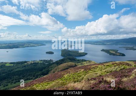 Blick über das südliche Ende des Loch Lomond vom heidekrautbedeckten Conic Hill unter einem bewölkten blauen Himmel. Auf dem West Highland Way Stockfoto