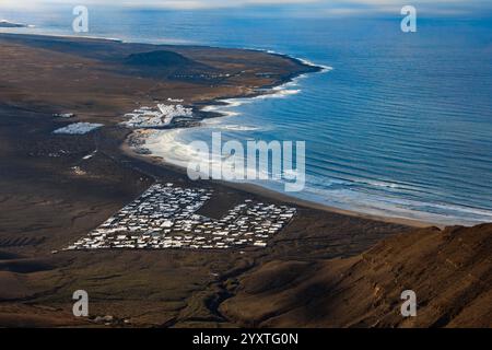 Blick aus der Vogelperspektive auf Caleta de Famara Village und Strand an einem sonnigen Tag, Lanzarote, Kanarische Inseln, Spanien Stockfoto