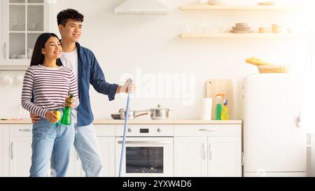 Junge asiatische paar wischen Boden in der Küche Stockfoto