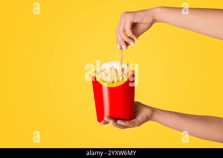 KHARKIV, UKRAINE - 4. APRIL 2020: Junges Mädchen, das eine Packung pommes von McDonald's auf rosa Hintergrund hält Stockfoto