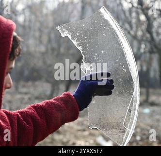 Srinagar, Indien. Dezember 2024. SRINAGAR, INDIEN – 17. DEZEMBER: Ein Junge zeigt ein Stück gefrorenes Eis an einem kalten Wintermorgen am 17. Dezember 2024 in Srinagar, Indien. Kaltwelle Griffe Kaschmir, da Srinagar die minimale Temperatur bei minus 5,3 Grad Celsius aufzeichnet. (Foto: Waseem Andrabi/Hindustan Times/SIPA USA) Credit: SIPA USA/Alamy Live News Stockfoto