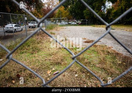 Blick durch den Maschendrahtzaun, der in ein leeres Grundstück in der Innenstadt von Sacramento mündet. Stockfoto