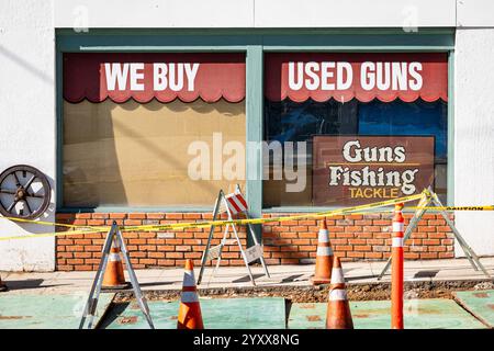 Ein Laden, der gebrauchte Waffen und Angelausrüstung an der High Street in der Innenstadt von Auburn kauft und verkauft, mit Baukegeln und Arbeiten davor. Stockfoto