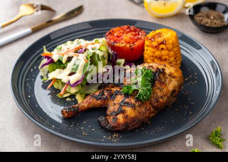 Hähnchenhälfte gebacken in einer Sauce aus Knoblauch, Soja, Ingwer und Honig. Teller mit gebackenem Mais, Salat und Tomaten. Stockfoto