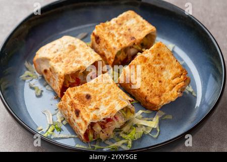 Hühnchen-Shawarma-Sandwich, frische Brötchen, gegrilltes Fleisch und Salattortilla-Wrap mit weißer Sauce. türkischer Döner Kebab auf einer Lavash - Shawarma Chicke Stockfoto
