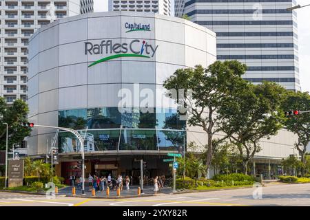 Vor dem Raffles City Shopping Centre in Singapur versammeln sich Menschenmassen, die ein pulsierendes Einkaufserlebnis in einem modernen, urbanen Setting hervorheben., Singapur. Stockfoto