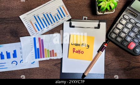 Konzept der Liquiditätsquote Schreiben Sie auf Haftnotizen, die auf Holztisch isoliert sind. Stockfoto
