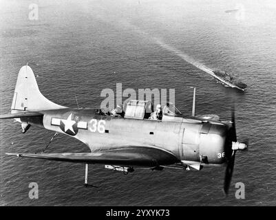 Eine US Navy Douglas SBD-5 Dauntless der Bombing Squadron 10 (VB-10), die im Landemuster über dem Flugzeugträger USS Enterprise (CV-6) während des Einsatzes im Pazifik abgebildet ist Stockfoto