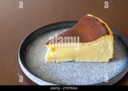 Ein Stück cremiger baskischer Käsekuchen mit karamellisierter Platte serviert auf einem weißen Teller in einem lokalen Café auf den Philippinen Cebu Stockfoto