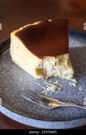 Ein Stück cremiger baskischer Käsekuchen mit karamellisierter Platte serviert auf einem weißen Teller in einem lokalen Café auf den Philippinen Cebu Stockfoto