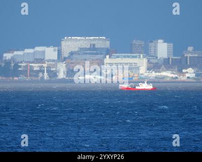 Sheerness, Kent, Großbritannien. Dezember 2024. Wetter in Großbritannien: Southend auf dem Meer, Skyline von Essex, die von der Sonne in der Ferne während des Sturmwetters in Sheerness, Kent, beleuchtet wird. Quelle: James Bell/Alamy Live News Stockfoto