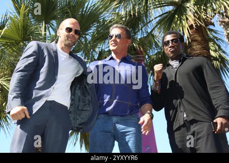 Jason Statham (l-r), Sylvester Stallone und Wesley Snipes nehmen am 18. Mai 2014 an der Fotokonferenz von Expandables 3 während des 67. Internationalen Filmfestivals von Cannes vor dem Hotel Carlton in Cannes, Frankreich, Teil Stockfoto