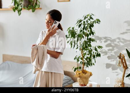 Eine junge afroamerikanerin putzt und chatscht am Telefon in ihrer modernen Wohnung. Stockfoto