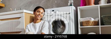 Eine junge Afroamerikanerin macht Spaß, ihre Wohnung zu putzen, einen aufgeräumten Wohnraum zu zeigen, ein Banner Stockfoto