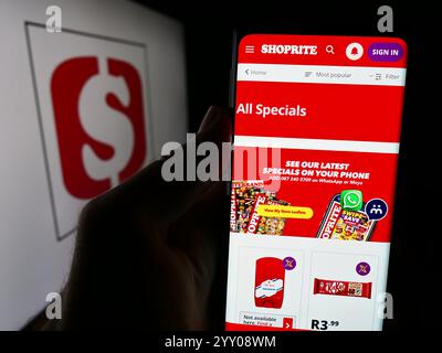 Deutschland. August 2024. In dieser Fotoabbildung hält eine Person ein Smartphone mit der Webseite des südafrikanischen Supermarktunternehmens Shoprite vor dem Logo. Quelle: SOPA Images Limited/Alamy Live News Stockfoto