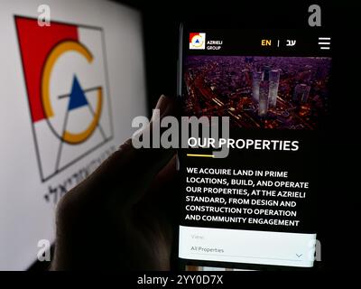 Deutschland. Juli 2024. In dieser Fotoabbildung hält eine Person ein Smartphone mit der Webseite der israelischen Immobiliengesellschaft Azrieli Group Ltd. Vor dem Logo. (Credit Image: © Timon Schneider/SOPA Images via ZUMA Press Wire) NUR REDAKTIONELLE VERWENDUNG! Nicht für kommerzielle ZWECKE! Stockfoto