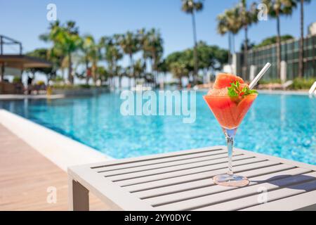 Frischer roter Cocktail mit Eis im Glas im Swimmingpool. Tropischer Saft bei Luxusurlauben. Konzept Sommerurlaub und Reisen Stockfoto