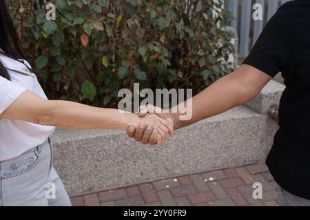 Nahaufnahme eines starken Handschlags zwischen zwei Personen, der Stärke, Vertrauen, Partnerschaft und Respekt symbolisiert. Hebt Einheit und Zusammenarbeit in einer vielfältigen Welt hervor. Stockfoto