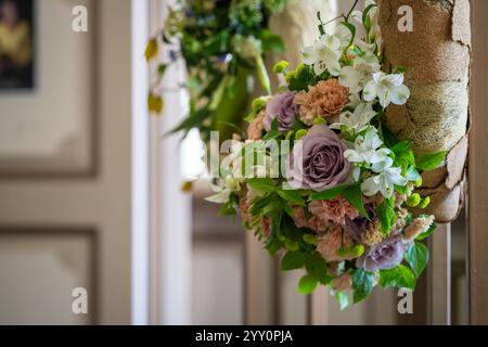 Ein Detail eines Blumenarrangements mit pastellfarbenen Blumen. Das Arrangement besteht aus einer zarten, violetten Rose und zarten, alten rosa Nelken. Stockfoto