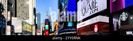 NEW YORK, NY, USA - 13. DEZEMBER 2024: Panoramablick vom Times Square, während farbenfrohe Plakatwände die Gegend unter einem klaren blauen Himmel beleuchten Stockfoto