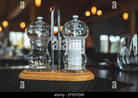 Salz- und Pfefferstreuer auf Holzbasis in einem Restaurant drinnen. Stockfoto