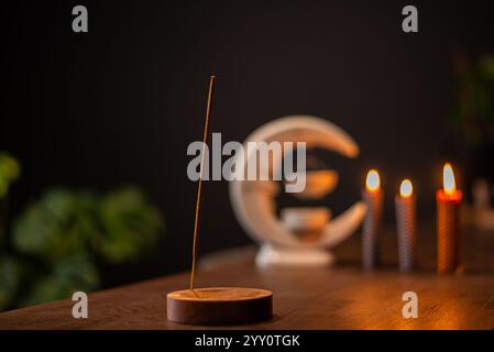 Räucherstäbchen raucht auf einem Holzständer auf dunklem Hintergrund. Aromatherapie, Rauch beim Verbrennen von Weihrauch. Rauch für Gebete und Meditation. Beten zu Stockfoto