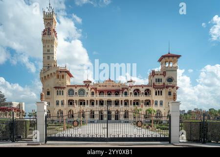 Der Montaza-Palast in Alexandria, Ägypten, bietet eine großartige Architektur mit komplizierten Details, einen majestätischen Turm und einen Eingangstor unter einem lebendigen Himmel. Stockfoto