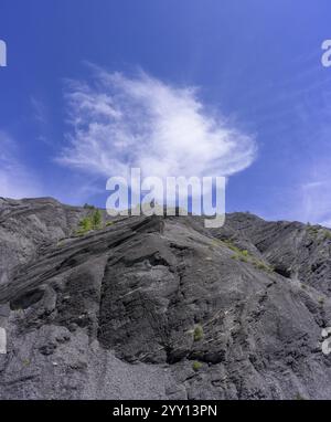 Dunkler Schiefer und weiße Wolke vor blauem Himmel, Entraunes, Departement Alpes-Maritimes, Frankreich, Europa Stockfoto