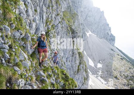 Zwei Bergsteiger mit Helmen klettern auf einer Felswände, Aufstieg zur Ackerlspitze, Wilder Kaiser, Kaisergebirge, Tirol, Österreich, Europa Stockfoto