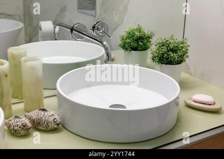 Innenausstattung des Badezimmers mit weißem Waschbecken und großem Spiegel in einem modernen Apartment Stockfoto
