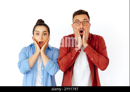 Schockierte Männer und Frauen arabischer oder kaukasischer Herkunft, beide halten ihre Hände ungläubig an ihre Gesichter, drücken Überraschung und Verwunderung aus, lässige Kleidung, stehen auf isoliertem weißen Hintergrund Stockfoto