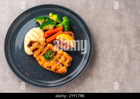 Gegrillte Lachsfilets mit Mentai-Sauce und Kartoffelpüree auf schwarzer Platte mit negativem Textfeld. Stockfoto