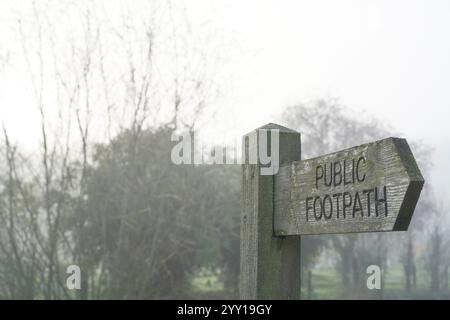 Nahaufnahme eines hölzernen öffentlichen Fußweges an einem nebeligen Tag in Großbritannien. Stockfoto