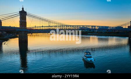 Luftaufnahme der Roebling Bridge bei Sonnenuntergang mit Calm River und Boot Stockfoto