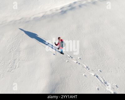Luftbild einer aktiven Seniorin beim Wandern im Tiefschnee im Hochhaedrich-Gebiet des Bregenzer Waldes in Vorarlberg, Österreich Kategorie Sport Stockfoto