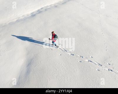 Luftbild einer aktiven Seniorin beim Wandern im Tiefschnee im Hochhaedrich-Gebiet des Bregenzer Waldes in Vorarlberg, Österreich Kategorie Sport Stockfoto