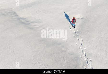Luftbild einer aktiven Seniorin beim Wandern im Tiefschnee im Hochhaedrich-Gebiet des Bregenzer Waldes in Vorarlberg, Österreich Kategorie Sport Stockfoto